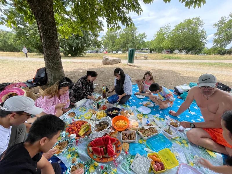 Gruppe beim Picknick auf Decken im Park