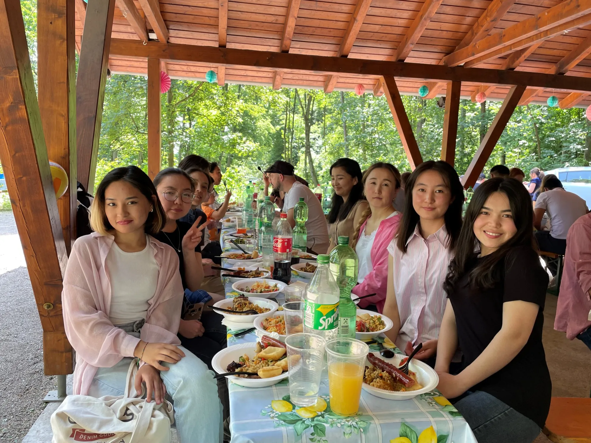 Sommerfest von ISTAN: Auszubildende, Familien und Partner an der langen Tafel unterm Pavillon